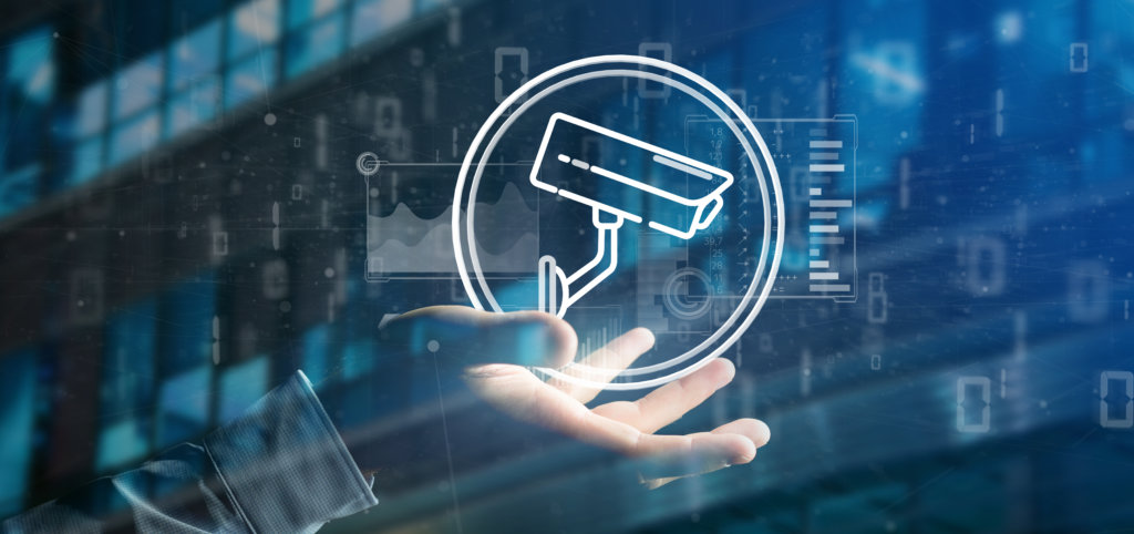 Vista di una mano di uomo d’affari che tiene in mano un’icona di sistema di telecamere di sicurezza e dati statistici in sottofondo in formato 3D
